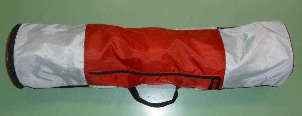 Das Bild zeigt eine rot-weiße Balltasche für 5 Volleybälle. Dabei kann die Balltasche entweder am Ende oder von der Seite über jeweils einen schwarzen Reissverschluss geöffnet werden.