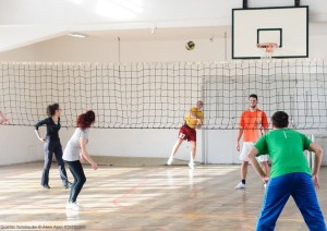 Das Foto zeigt eine Hobbygruppe aus Erwachsenen, die Volleyball spielen.