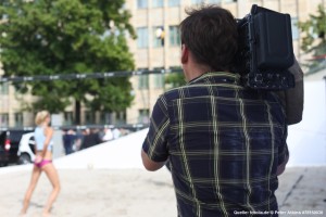 Das Bild zeigt einen Kameramann, welcher ein Beachvolleyballspiel der Smart-Beachtour filmt.