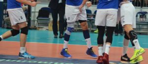 Das Foto zeigt Volleyballer in weißen Hosen auf den Spielfeld.