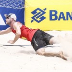 Das Foto zeigt Beachvolleyballer Stefan Windscheif bei der Abwehr im Sand.