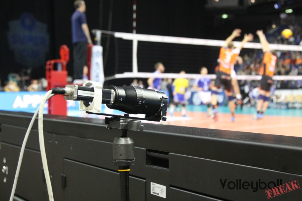 Das Foto zeigt Eine der unzähligen Kameras für das Videochallenge-Sytem beim Volleyball Supercup 2016. Im Hintergrund unscharf ist ein Spielszene vom Supercupspiel VFB Friedrichshafen gegen BR Volleys