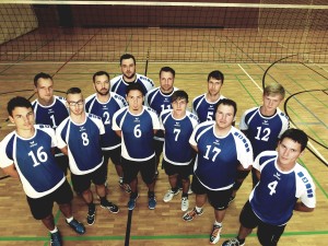 Das Teamfoto der Herrenmannschaft vom Kremmener SV in Halbkreis-Auftellung. Im Hintergrund sieht man das Volleyballnetz.