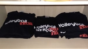 Das Foto zeigt schwarze Volleyballfreak T-Shirts in 3 Stapeln in einem Kleiderschrank.