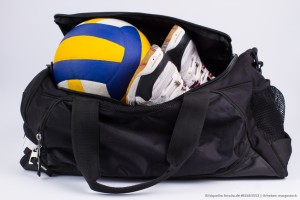 Das Foto zeigt einen Volleyball und Schuhe in einer Sporttasche. Dies soll Volleyball-Zubehör symbolisieren.