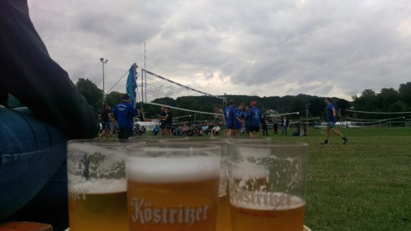 Das Foto zeigt die Biergläser für die Bierauszeit des Eröffnungsspiels auf dem Otto Scharfenberg Turnier, welches im Hintergrund zu sehen ist.