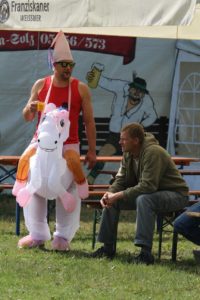 Das Foto zeigt einen Mann im Einhorn-Kostüm auf dem Otto-Scharfenberg-Turnier in Bad Liebenstein.