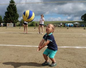Kind versucht einen Mikasa Volleyball zu baggern.