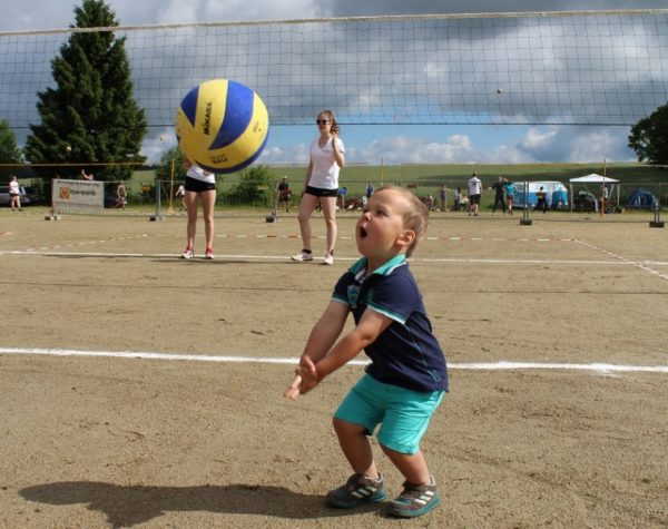 Kind versucht einen Mikasa Volleyball zu baggern.