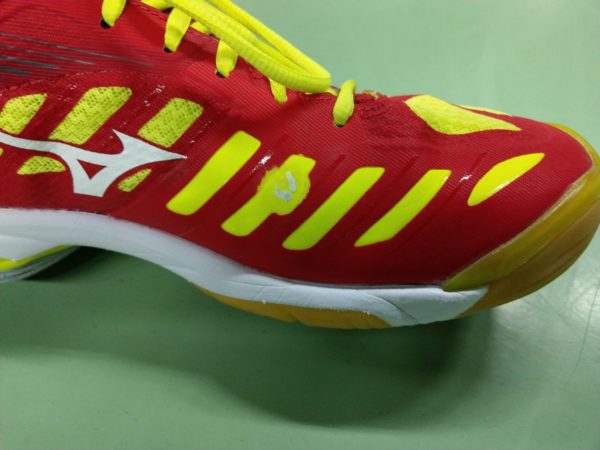 Das Foto zeigt den roten Mizuno Wave Lightning Z4 mit einem kleinen Schaden durch das Training.