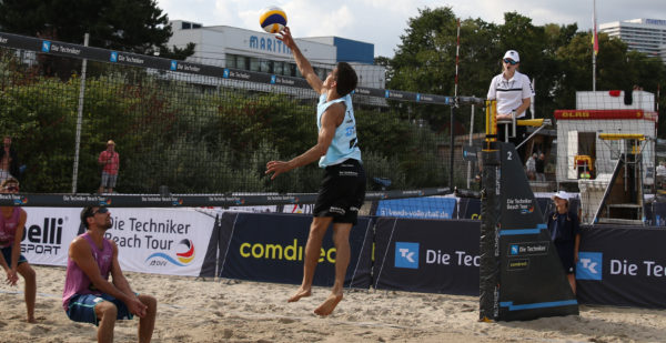 Das Foto zeigt einen Beachvolleyballer beim Pokeshot für einen Angriff im Beachvolleyball